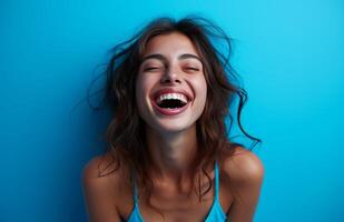 AI generated Woman in blue outfit laughing joyfully showcasing her bright smile against a vibrant blue background, people laughing picture photo