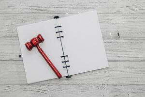 Notebook with rings, checkered sheets, court gavel for making decisions. photo