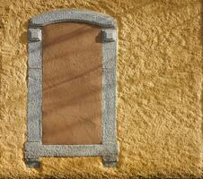 Yellow wall with a closed and boarded window photo