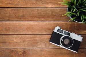 Wooden background with a camera, design template for adding text photo
