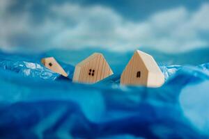 Climate Change Effect, Environment Issue. Conceptual Photo. Wooden Miniature House in Flood. Environmental Impact. Global Issues, Desertification, Water, Pollution, and Energy photo