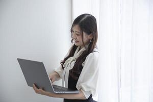 un trabajando japonés mujer por remoto trabajo en el hogar oficina de cerca foto
