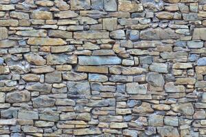 Old wall stone texture and background with rustic tiles design photo