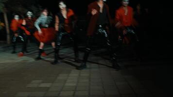 groupe de danseurs performant une routine à nuit avec spectaculaire éclairage et vibrant rouge costumes, mettant en valeur énergie et mouvement. video
