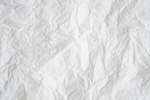 Wrinkled or crumpled white stencil paper or tissue after use with large copy space used for background texture photo