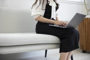 A Japanese woman typing laptop by remote work in the office faceless composition photo