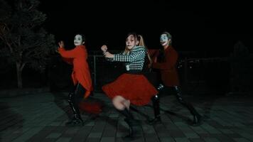 Tres personas en de moda trajes posando a noche en un urbano calle. video