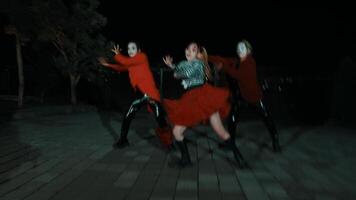 Group of people in Halloween costumes dancing at night with spooky makeup and masks, motion blur effect. video