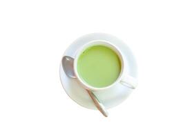 parte superior ver de caliente condensado Leche matcha verde té servido en blanco taza y pequeño plato con pequeño té cuchara aislado en blanco antecedentes con recorte camino foto