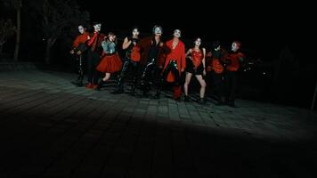 Group of people in Halloween costumes posing at night. video