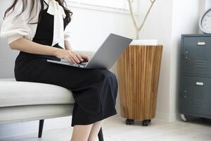 A Japanese woman typing laptop by remote work in the office faceless composition photo