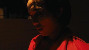 Close-up of a thoughtful person in low light, with a dramatic shadow cast across their face. video