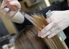 hairdresser's hands with scissors and a comb haircut client. selective focus.High quality photo