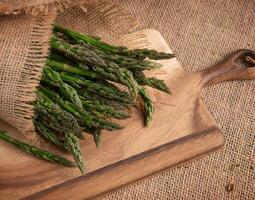 Bunches Fresh green asparagus on burlap on a board. top view - image. High quality photo