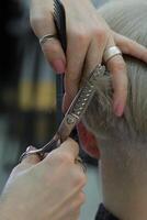 hermosa peluquero manos sostener tijeras y peine y cortar el modelo cabello. selectivo foco.alto calidad foto