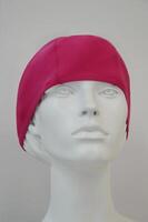 Cap for swimming in the pool and on the beach. A pink bathing cap for women on a mannequin in the trading floor of the store. photo