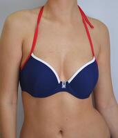 Women's swimming suit. A blue bra from a bikini swimsuit on a slim model. Women's clothing for the beach and swimming in the water. photo