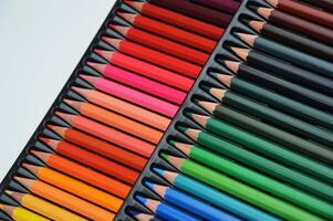 A row of colored pencils in a palette, lying in a line. Nice set. Tools for creativity, drawing, school, learning photo