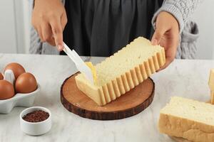 Spreading Butter Margarin on Roti Bakar Bandung Bread photo