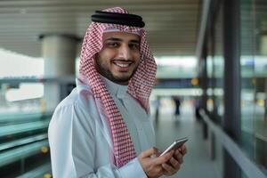 AI generated Smiling Man in Traditional Emirati Attire with Smartphone with AI generated. photo