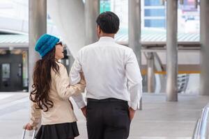 Diverse couple with luggage walking in city, Couple walking with suitcases to boarding gate at airport photo