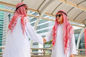 árabe medio oriental empresario apretón de manos, negocio reunión con árabe hombre y sacudida manos en saludos foto