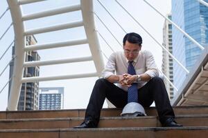 Lonely engineer man lost in a depression sitting on the stair, feeling sad concepts photo