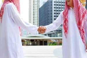 árabe medio oriental empresario apretón de manos, negocio reunión con árabe hombre y sacudida manos en saludos foto
