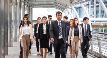 Group of happy young business team, businesspeople walking the outdoor office together success teamwork for concepts photo