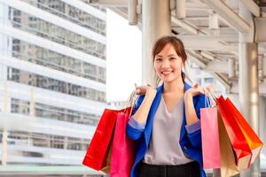 joven mujer que lleva compras pantalones mientras caminando a lo largo el calle. compras conceptos foto