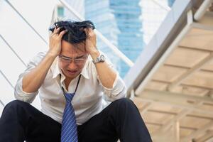 man lost in a depression sitting on the stairs, Serious engineer man in construction site, feeling sad concepts photo