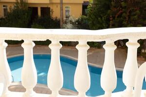view of the pool through the balusters of the balcony. High quality photo