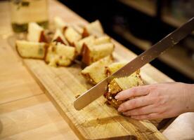 baker hands slicing freshly baked cupcakes with a long knife. selective focus. photo