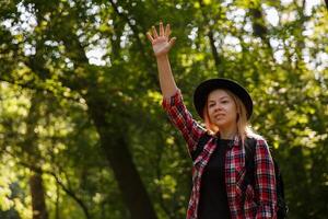 young caucasian woman in a hat waving in greeting. blurred background, selective focus. High quality photo