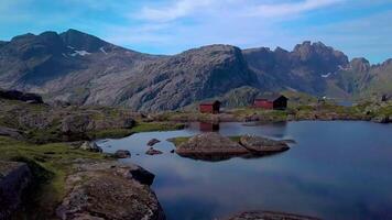 een vlucht over- een meer en een klein huis in de mooi bergen van de lofoten eilanden. mooi landschap van noordelijk Noorwegen. lofoten eilanden. Munkebu is een beroemd plaats, populair voor toeristen. video