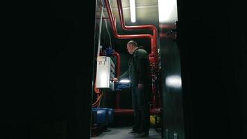 mantenimiento ingeniero inspeccionando controlar sistema, mantenimiento ingeniero analizando y operando un eléctrico controlar panel en un técnico instalaciones habitación video