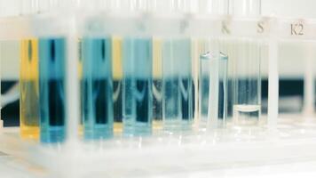 Laboratory Test Tubes with Colorful Chemicals, Close-up of test tubes in a rack with various colored chemicals in a lab. video