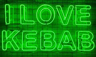 Neon shining sign in green color on a brick wall with the inscription or slogan I love kebab. Brick wall, background. Bright electric neon light. Cafe-restaurant Doner Kebab. photo