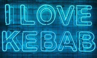 Neon shining sign in blue color on a brick wall with the inscription or slogan I love kebab. Brick wall, background. Bright electric neon light. Cafe-restaurant Doner Kebab. photo