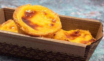 Lots of freshly baked desserts Pastel de nata or Portuguese egg tart. Pastel de Belm is a small pie with a crispy puff pastry crust and a custard cream filling. A small dessert, a cupcake. photo