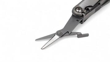 The scissors tool is pulled out of the multitool. Modern steel multitool with many tools isolated on white background. Compact and portable product. Pocket knife. EDC concept. Copy space. photo