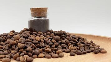 Coffee beans ground in a coffee grinder, mortar or mill in a small glass jar on the table. Coarse or medium grind are packed for storage. A drink made from roasted and ground grains. photo