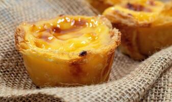Lots of freshly baked desserts Pastel de nata or Portuguese egg tart. Pastel de Belm is a small pie with a crispy puff pastry crust and a custard cream filling. A small dessert, a cupcake. photo