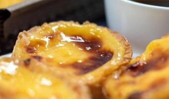 un montón de postres pastel Delaware nata o portugués huevo tarta con un blanco taza de negro café. pastel Delaware belma es un pequeño tarta con un crujiente soplo Pastelería corteza y un lactoso crema relleno. foto