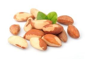 Brazil nuts with leafs on white close up photo