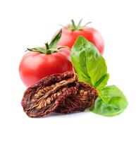 Dried tomato with fresh tomato and basil leaves on white backgrounds. Healthy food photo