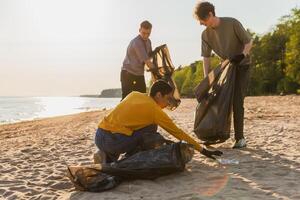 tierra día. voluntarios activistas recoge basura limpieza de playa costero zona. mujer y mans pone el plastico basura en basura bolso en Oceano costa. ambiental conservación costero zona limpieza foto