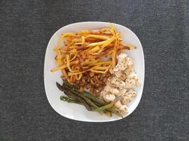 Homemade grilled chicken with french fries, eggplant and grilled asparagus, served on a white plate photo