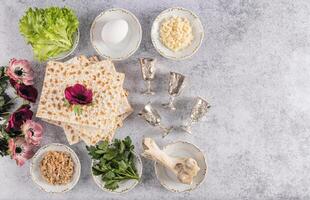 top view of traditional products for the Jewish holiday of Passover, flowers, silver glasses. Marble background. A copy space. postcard. Flat lay. photo