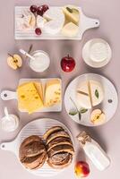 Fresh dairy products, bread, cheese, cottage cheese, sour cream on different white boards. Top vertical view. Flat lay. The concept of of Shavuot. photo